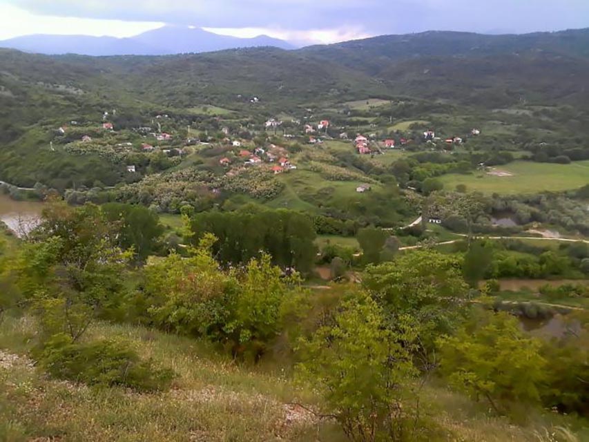 Panoramski pogled na selo Badar u okolini Katlanova, okruženo zelenim brdima i prirodom.